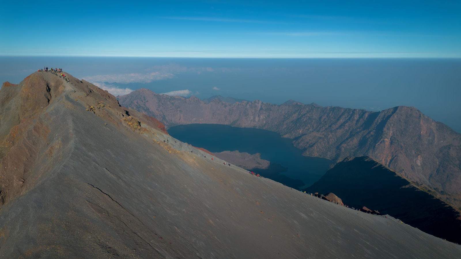 Hikers on the Mount Rinjani summit ridge above Segara Anak
